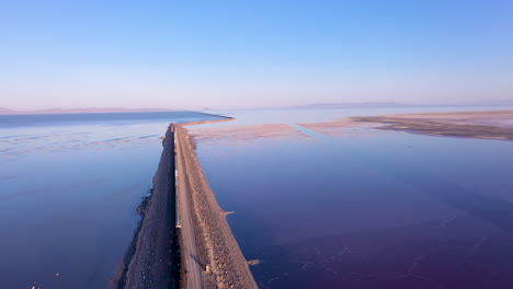 Drone-Volando-Sobre-El-Tren-De-Carga-Cruzando-La-Calzada-Del-Ferrocarril-Del-Gran-Lago-Salado,-Utah