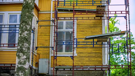 time lapse painting restoration of old house painting with scaffolding installed