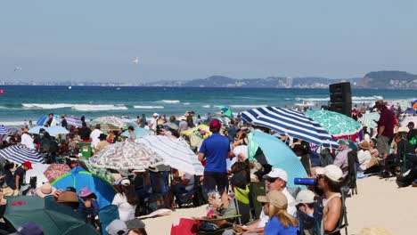 crowded beach scene with vibrant umbrellas and ocean view