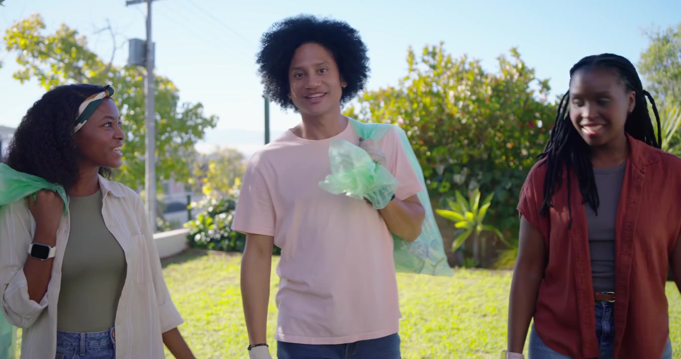 African American friends preparing green bags, gloves in yard for cleanup, gathering plastic bottle