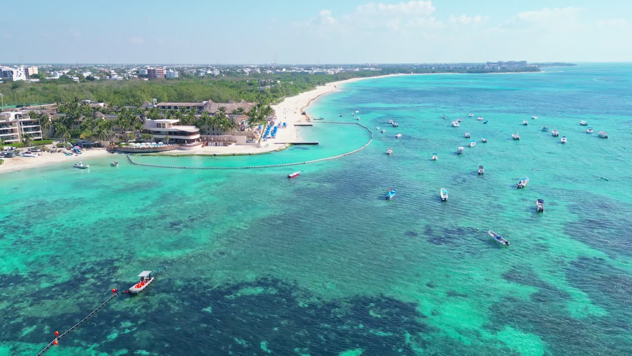 Turquoise blue waters and boats near a sandy beach in Playa del Carmen, Mexico