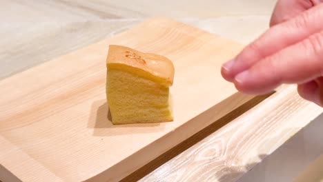 hand slicing bread on wooden board