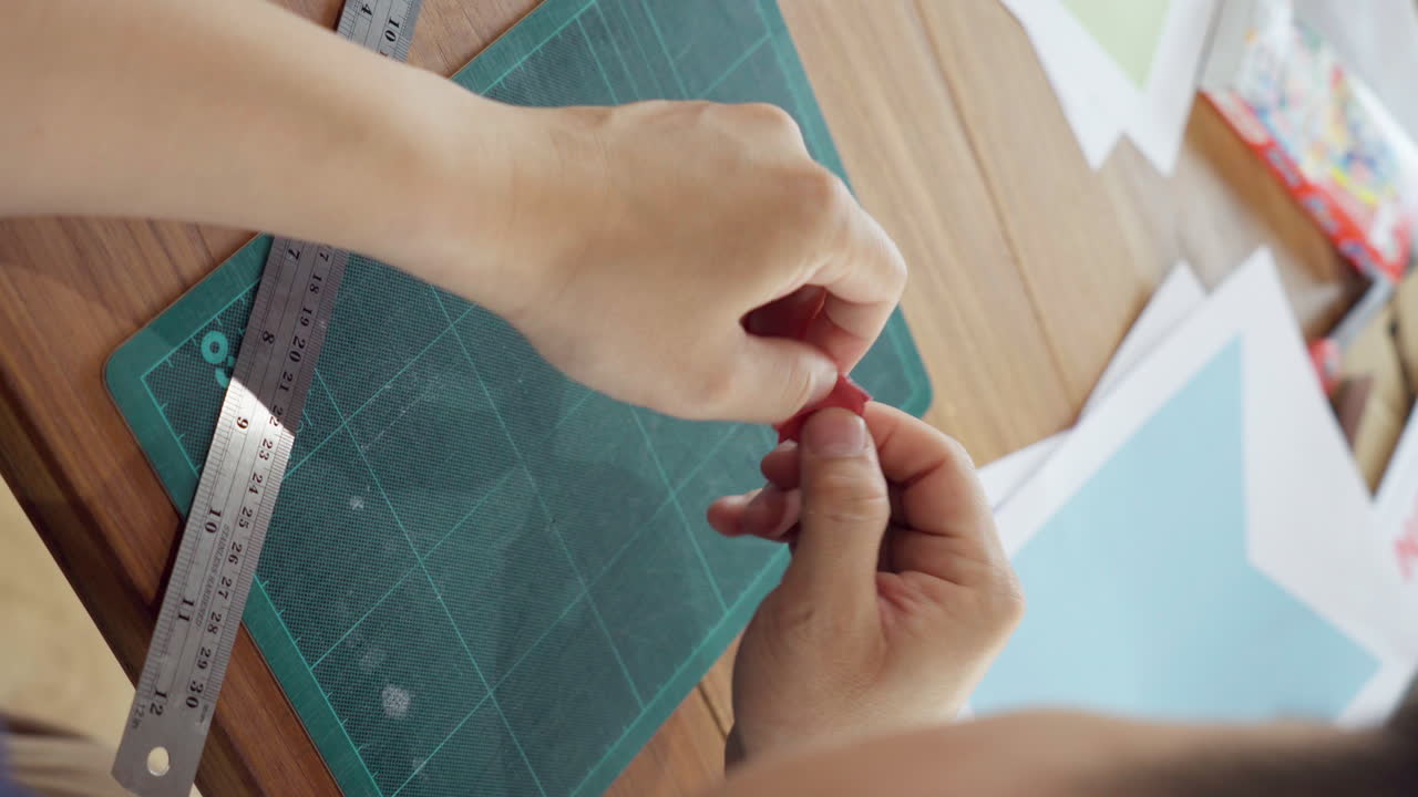 las manos rompen el papel en forma de corazón en pedazos pequeños.