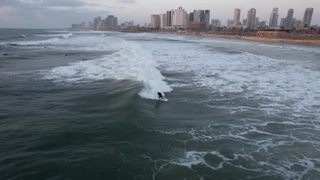 aerial view of surfers on the coast of tel aviv, israel - pull back, drone shot