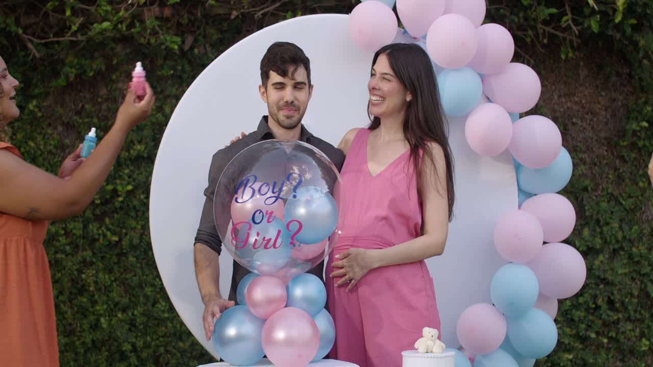 Couple's Joyful Gender Reveal Party with Pink and Blue Balloons