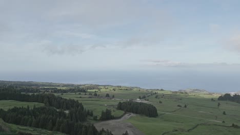 Expansive-view-of-São-Miguel-from-Miradouro-do-Pico-do-Carvão,-lush-greenery,-cloudy-sky