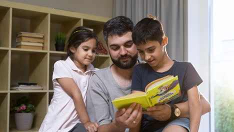 camera zooming on father, son and daughter in the living room.