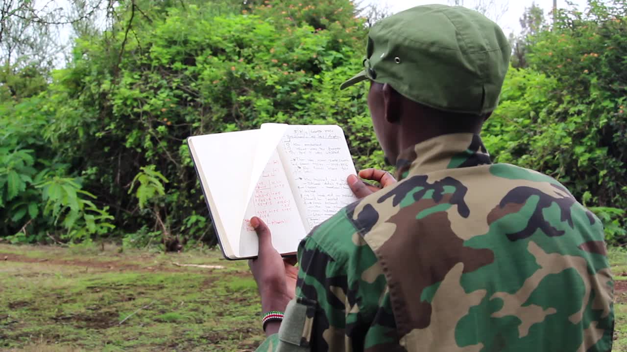 soldado africano pasando las páginas de su folleto de plan de ataque