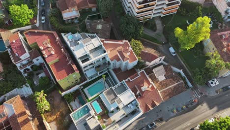 Drone circles above residential houses, capturing top-down views of pools and rooftops