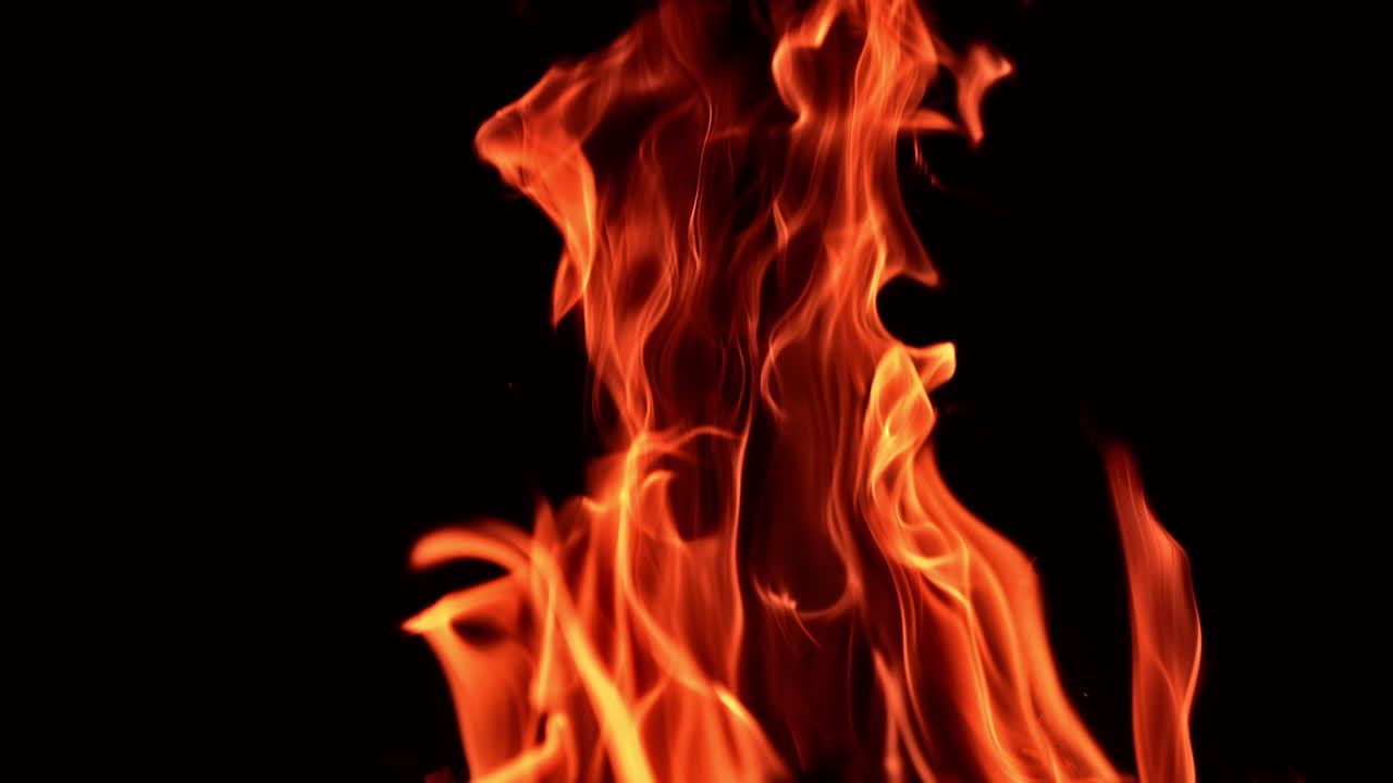 Beautiful tongues of flame from the campfire. Close up. Isolated blaze at black backdrop.