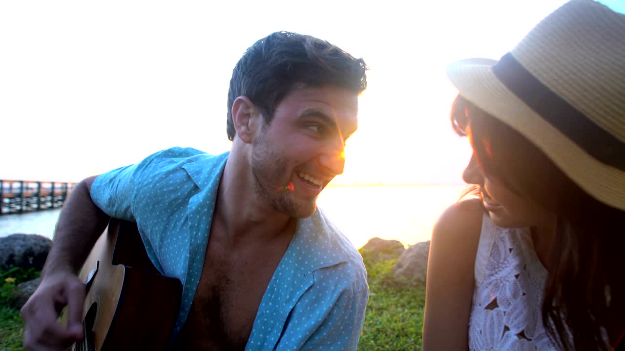 hombre y mujer multiétnicos con picnic en la playa