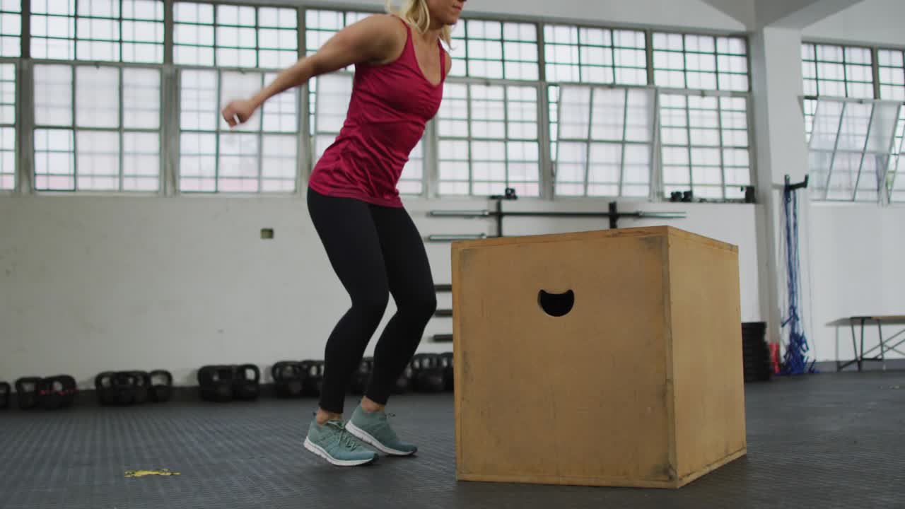 Female athlete doing box jumps for fitness, landing on box initiating floating icons for tracking