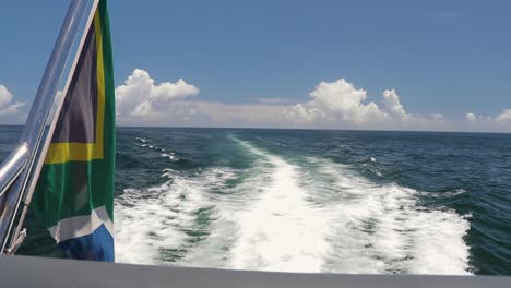 A-shot-of-a-long-water-wake-with-a-South-African-Flag-waving-in-the-wind