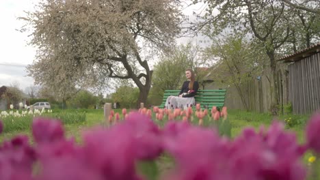 girl in a skirt is holding a blooming flower in a tulip garden