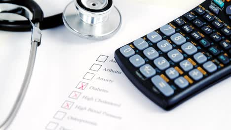 Primer-Plano-Del-Formulario-De-Evaluación-De-Salud-Con-Control-De-Diabetes-Y-Calculadora,-Estetoscopio