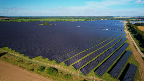 Toma-Aérea-Sobre-Un-Campo-Enorme-Con-Paneles-De-Generación-De-Energía-Solar-En-Polonia