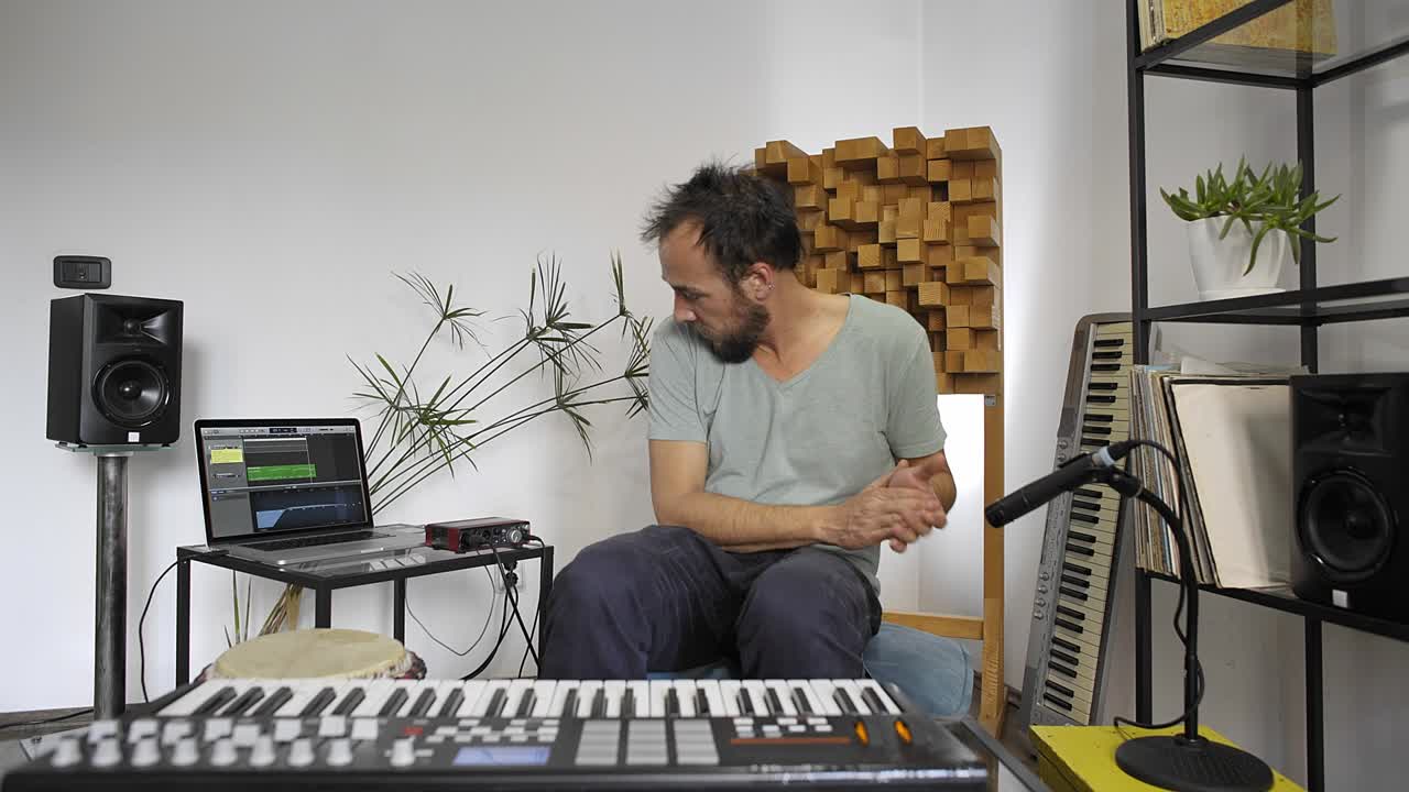 músico en el estudio de música en casa conectando el micrófono y probando.