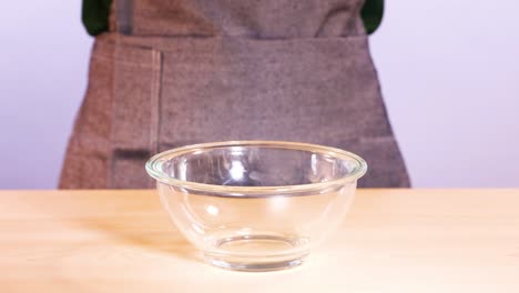 chocolate discs falling into a glass bowl