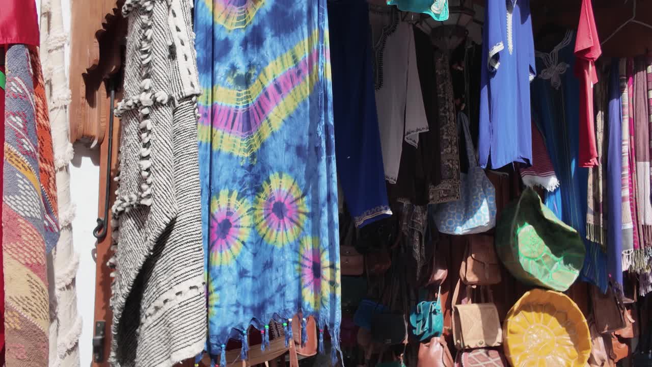 Colorful traditional garments and textiles displayed in Tangier Medina, Morocco