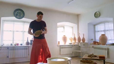 Masterful Potter at Work: Capturing the Art of Clay Shaping and Creation in a Serene Studio Environment