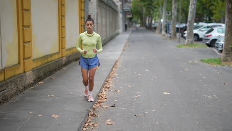 mujer corriendo por la calle de la ciudad