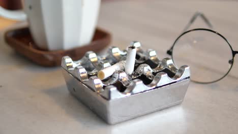 ashtray with cigarette butts and glasses