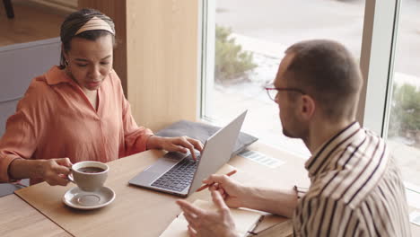 two businesspeople having meeting in cafe