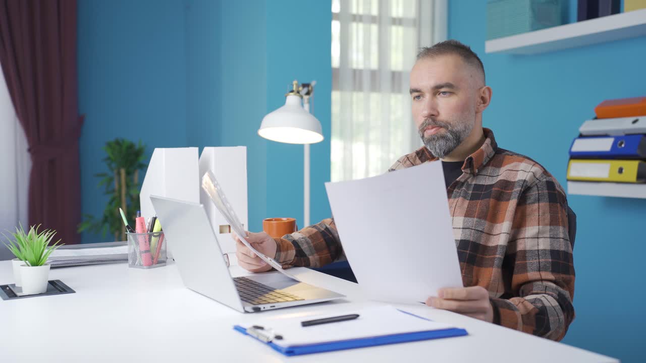 Freelance businessman looking at documents, working, evaluating.