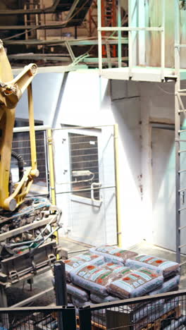 mechanical robot with artificial intelligence sorts bags on the conveyor. putting bags from line to the pallet. process closeup. vertical video