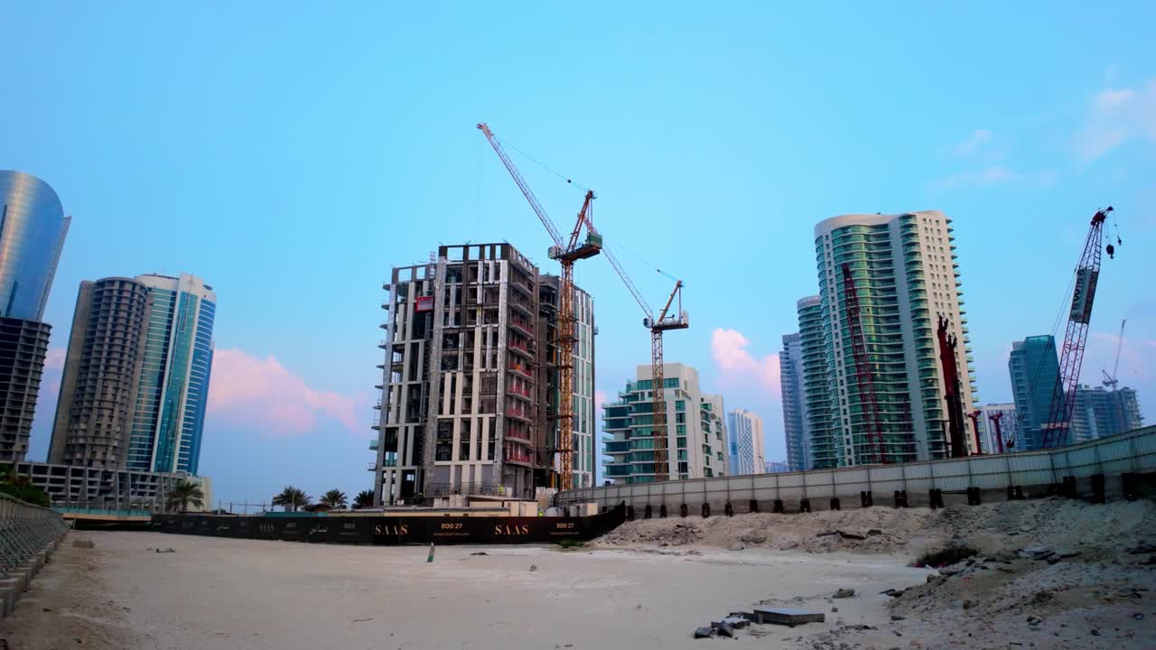 Cranes and skyscrapers rising against a vibrant morning sky on Al Reem Island, Abu Dhabi, United Arab Emirates. Showcases modern urban growth and construction progress on reclaimed land