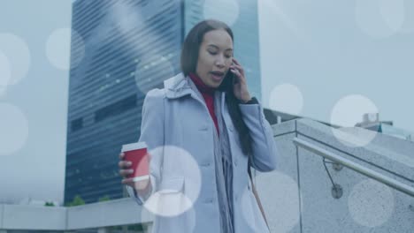 Video-of-lens-flare-over-biracial-woman-walking-to-work,-using-smartphone-in-street