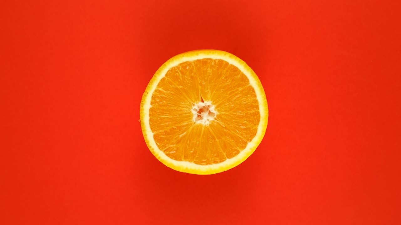 Orange fruit isolated on red background, rotate.