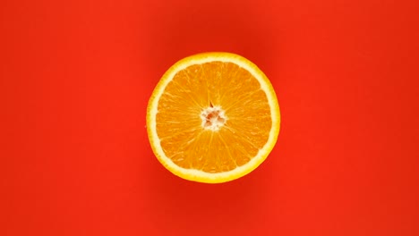 la fruta naranja aislada sobre un fondo rojo, girar.