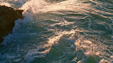 Foamy-water-splashing-at-crag-sunny-nature-close-up.-Stormy-marine-landscape