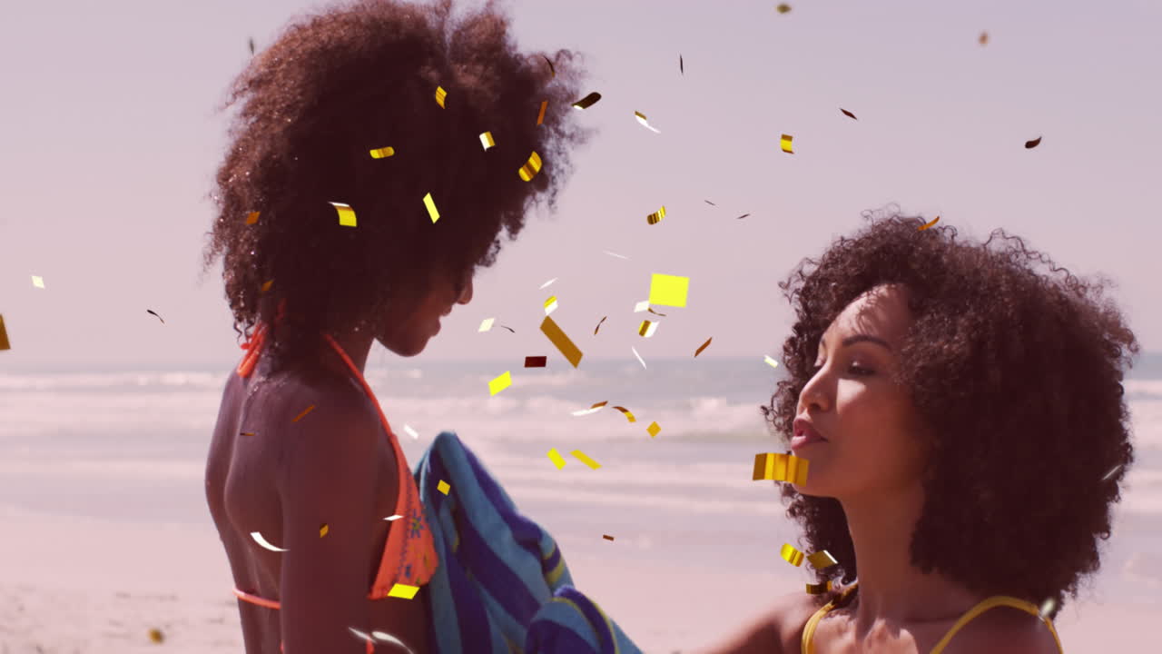 Animation of christmas confetti over biracial woman with daughter on beach
