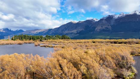 Aerial footage captures Glenorchy's vibrant autumn foliage and serene waters under a bright sky, framed by majestic mountains