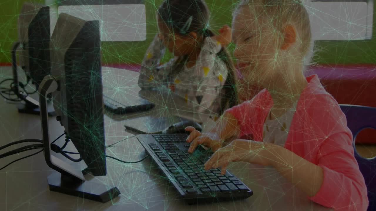 Blonde girl reaching keyboard for coding project in tech lab while other girl adjusting headphones