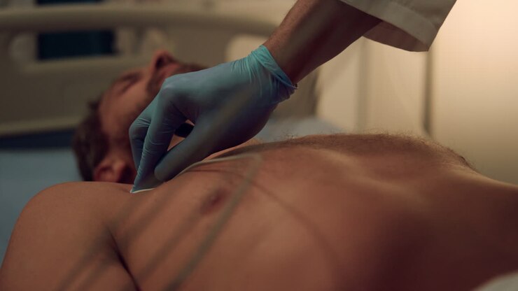 Cables on patient chest put by unknown cardiologist in modern hospital facility.