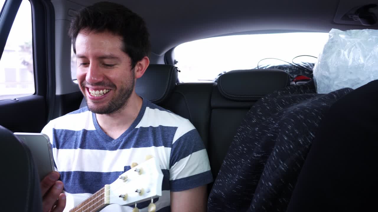 4k에서 하루 동안 학생에게 음악 수업을 주는 움직이는 차 안에서 비디오 통화를 하는 남자