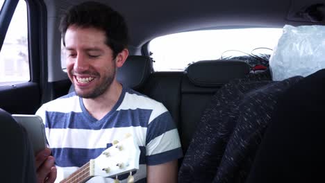 un hombre haciendo una llamada de video dentro de un coche en movimiento dando clases de música a un estudiante en el día en 4k