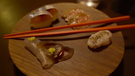 minimalistic sushi cuisine presented on wooden disc with chopsticks in vanguard restaurant