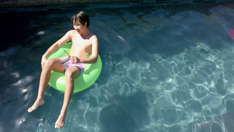 Un-Adolescente-Asiático-Disfruta-De-Un-Día-Soleado-En-La-Piscina,-Con-Espacio-Para-Copiar