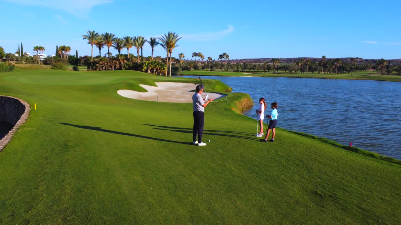 Golfers on a scenic golf course with lake and palm trees
