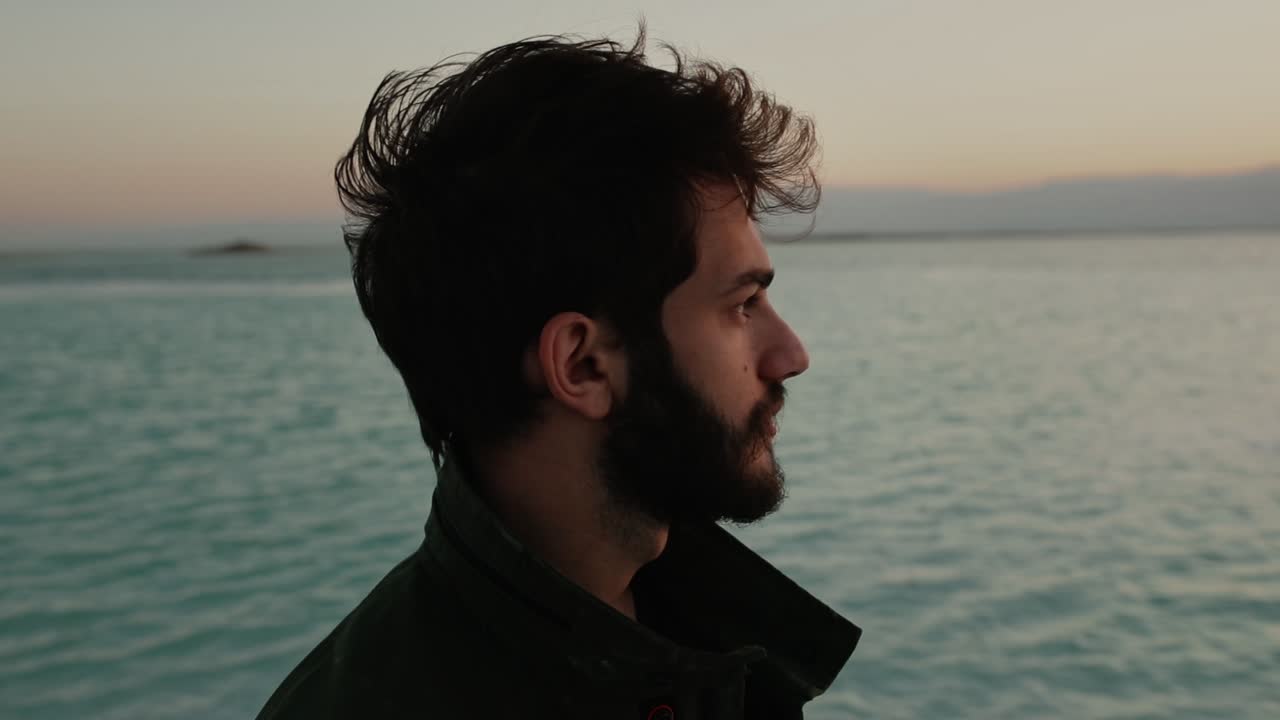 Profile view of Israeli man gazing out over Dead Sea at blue hour, men's health