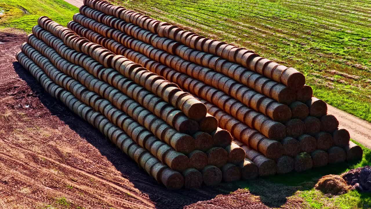 Luftfoto: Stak af stablet hø på en mark om dagen, udendørs, etablerende droneoptagelse.
