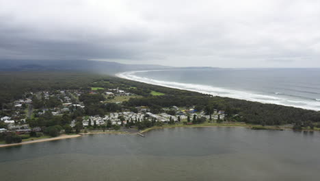 aerial drone shot over shoalhaven heads on a stormy day with the coastline stretching out to the horizon in south coast nsw australia