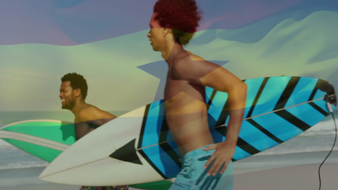 Carrying surfboards, two people on beach with flag animation overlay
