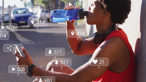 animation of notification and changing numbers, african american man drinking water and using phone