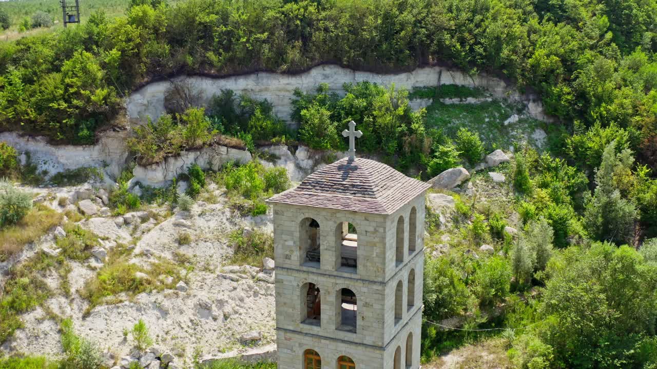 Stone building surrounded with nature. Unfinished church in the mountains. Tall architecture on the hill in summer. Motion camera around.