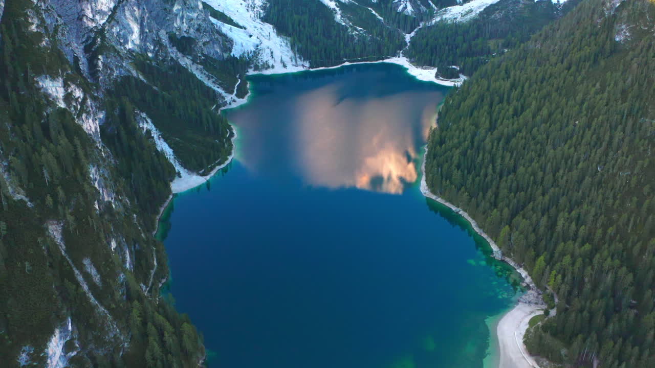 antena panorámica de las aguas prístinas del lago braies y los dolomitas prag cubiertos de nieve, italia